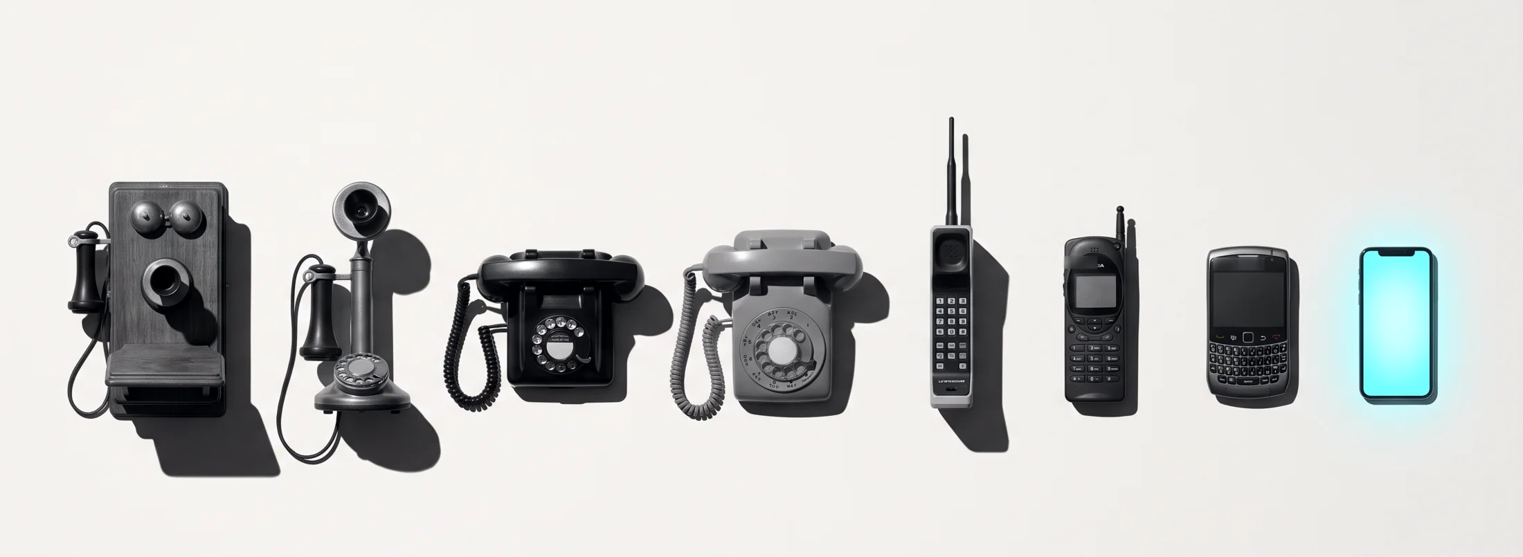 Acht Telefone in einer Reihe: vom Wandapparat aus dem 19. Jahrhundert über Kerzenständer, Wählscheibe und Tastenhandy bis zum Smartphone, das als einziges cyan leuchtet